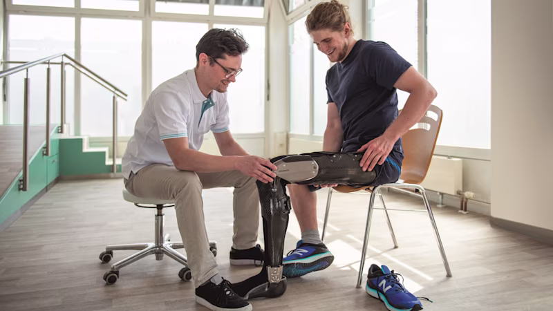 A clinician helps a client during a fitting for the Ottobock C-Brace