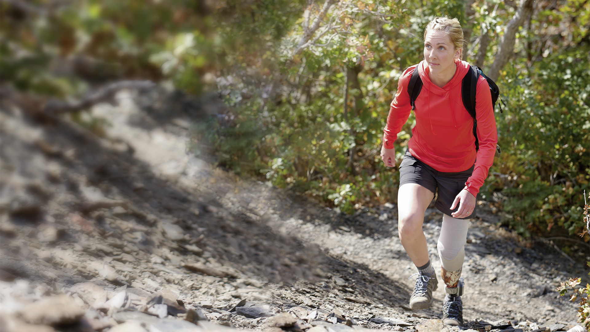 A hiking woman climbs a steep mountain path.