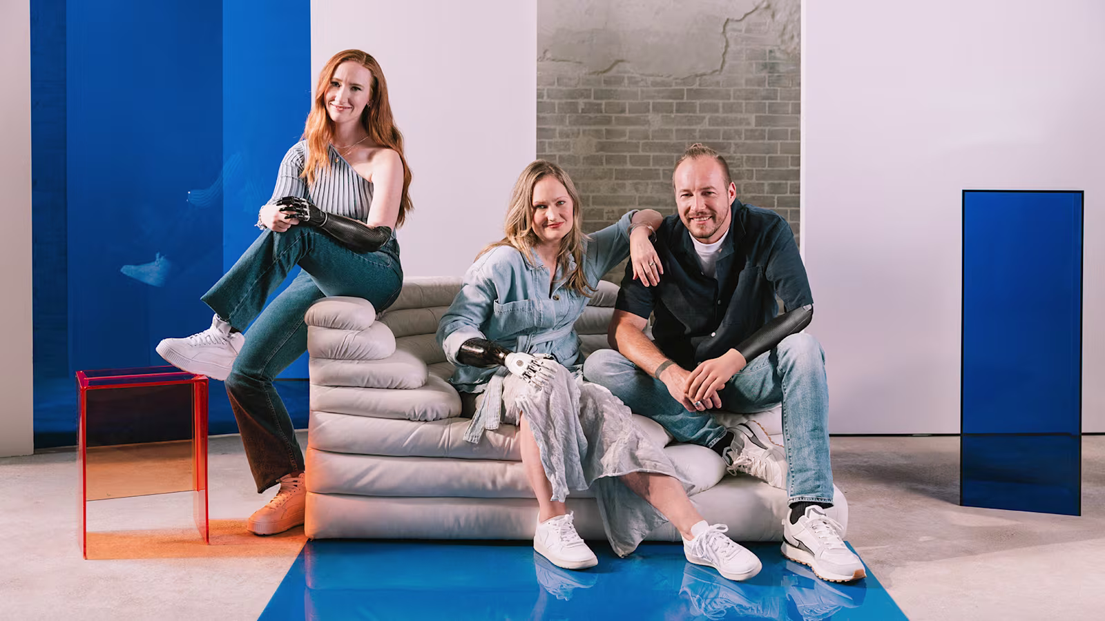 Three people with limb loss or limb difference using prosthetic arms and hands.