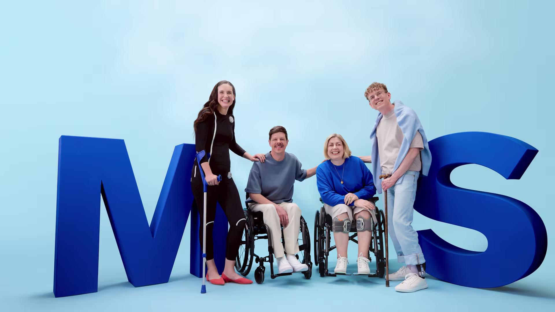 Ottobock product users standing smilingly in front of big blue MS letters