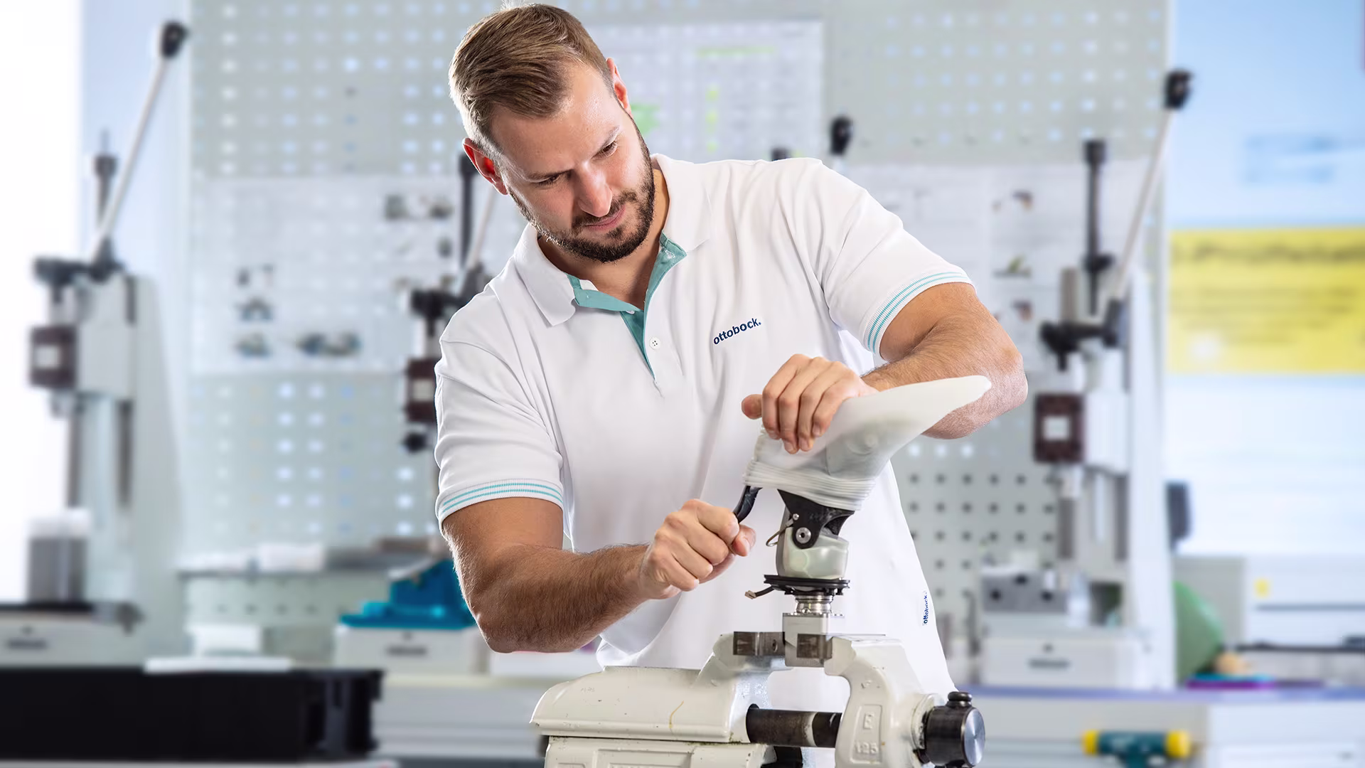 Ottobock technician assembling prosthetic limb in specialized workshop environment.
