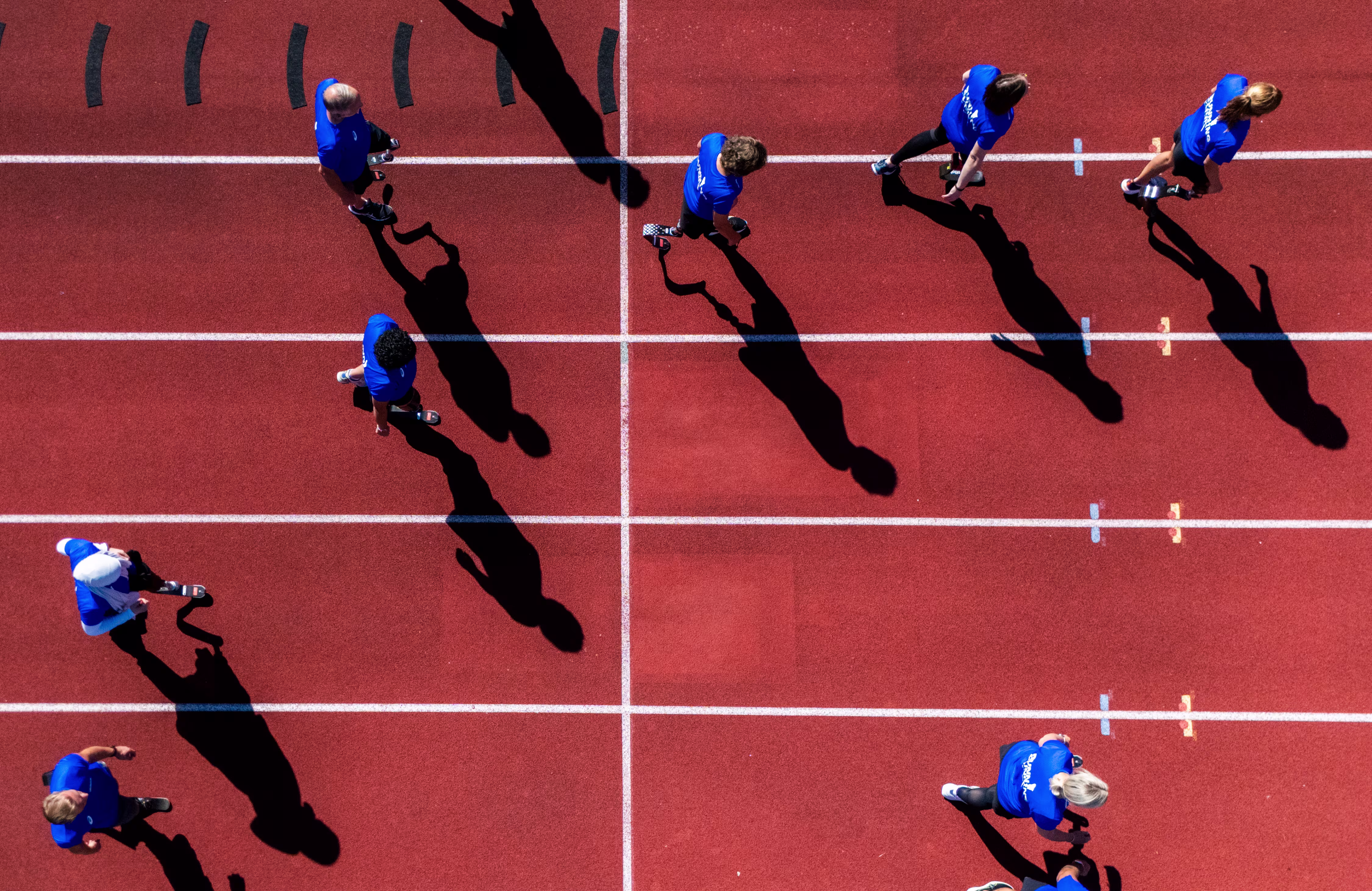 Teilnehmer der Running Clinic stehen gemeinsam auf dem Sportplatz und jubeln