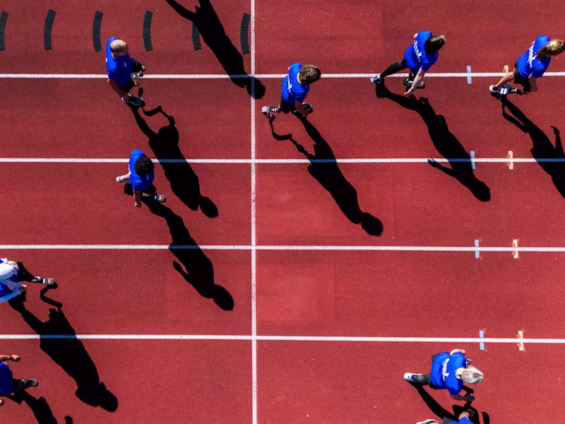 Teilnehmer der Running Clinic stehen gemeinsam auf dem Sportplatz und jubeln