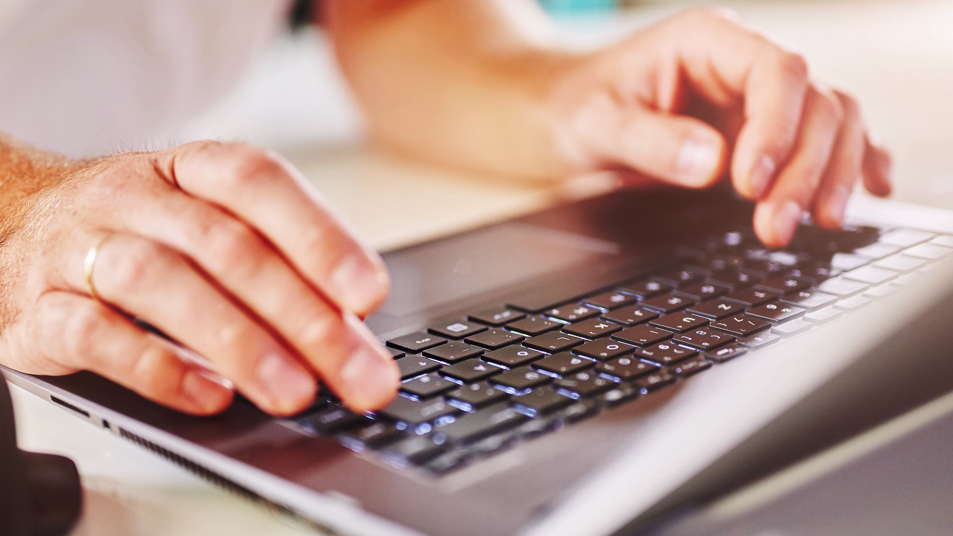 Un primer plano de alguien escribiendo en el teclado de su computadora portátil