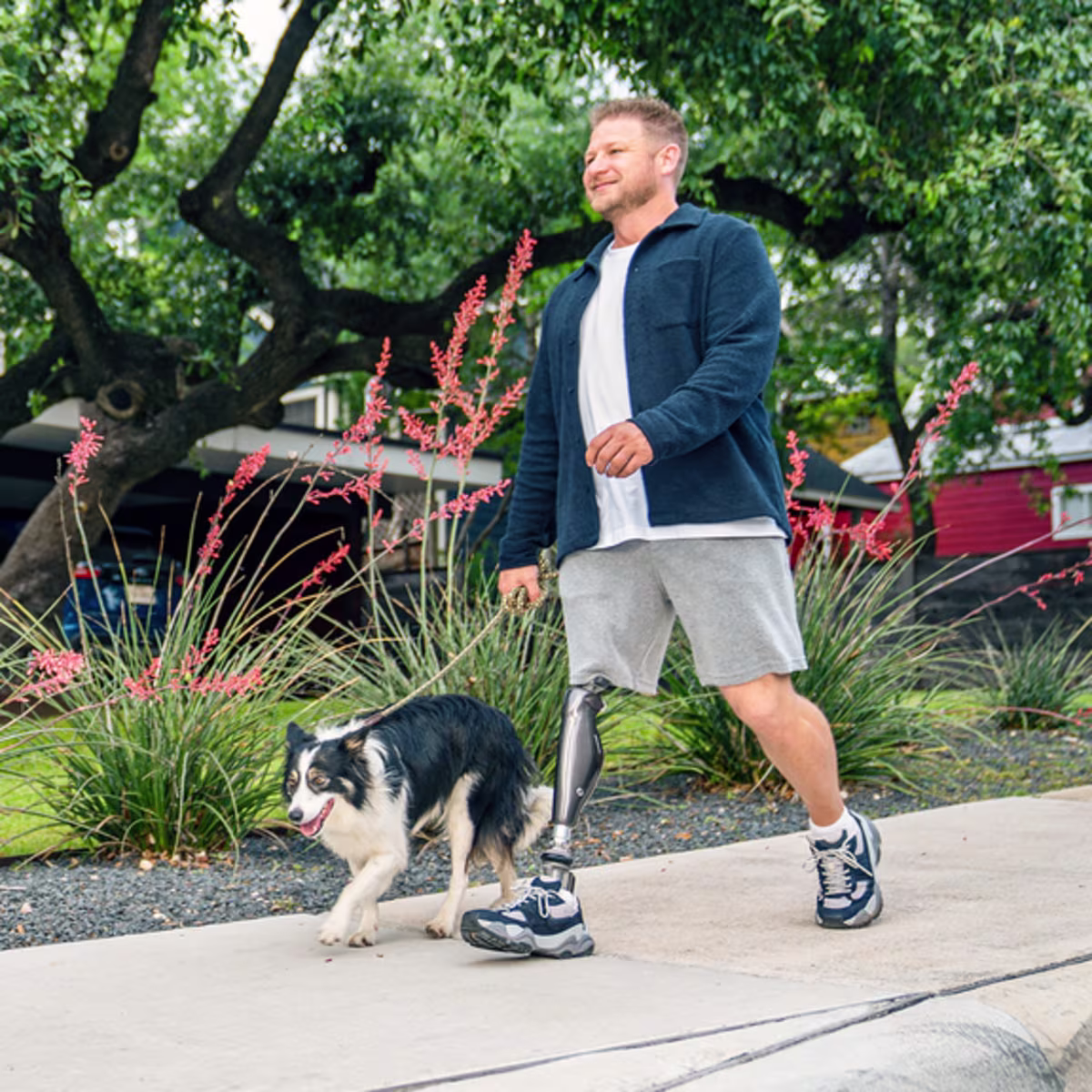 C-Leg user Chance is walking his dog on a sidewalk.