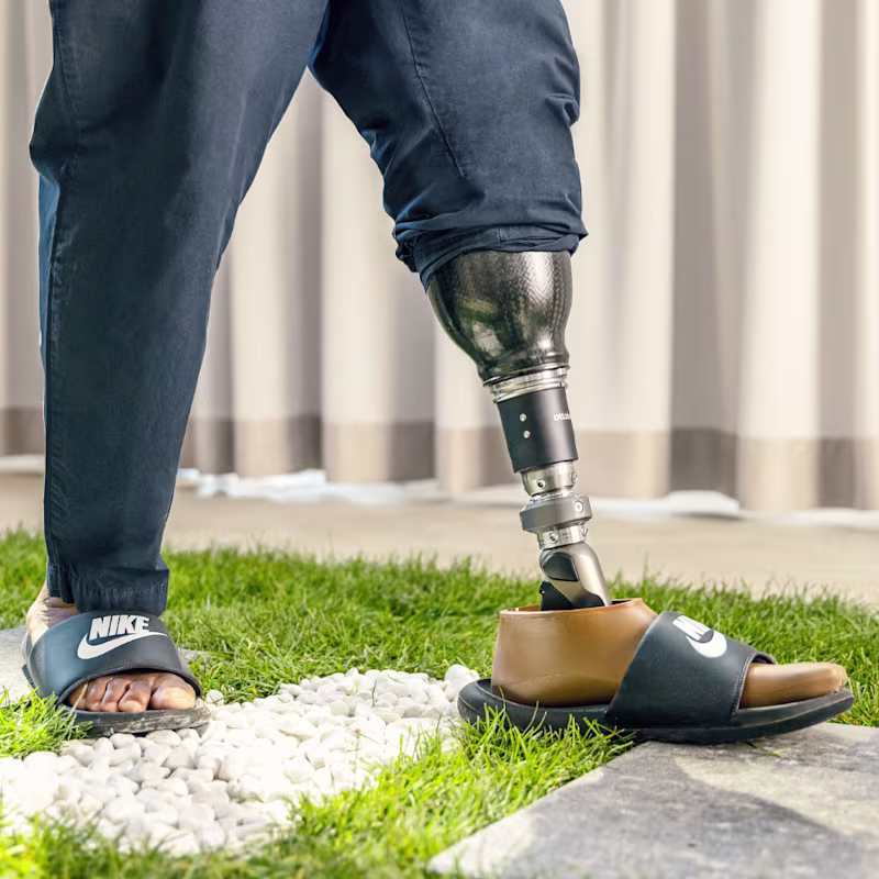 A man wearing a Taleo Adapt prosthetic foot from Ottobock walking across green turf