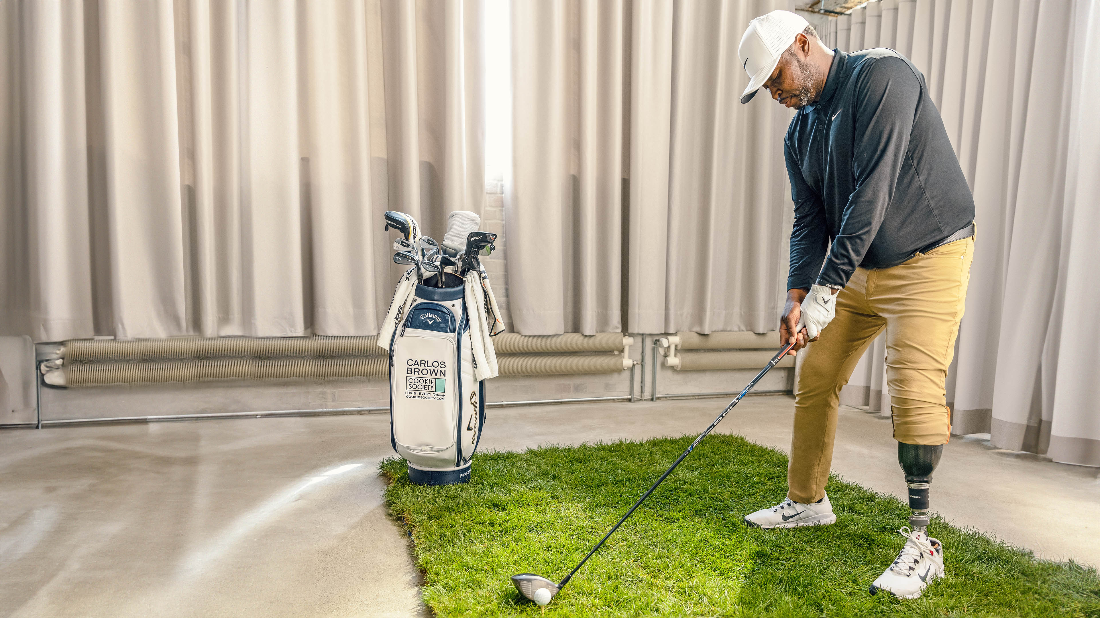 Ein Mann spielt Gold mit einem Indoor-Golfset und trägt dabei den Taleo Adapt Prothesenfuß von Ottobock.