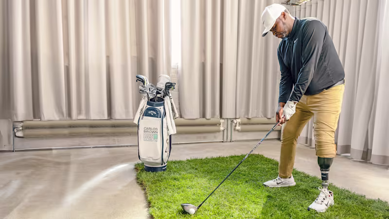 Ein Mann spielt Gold mit einem Indoor-Golfset und trägt dabei den Taleo Adapt Prothesenfuß von Ottobock.