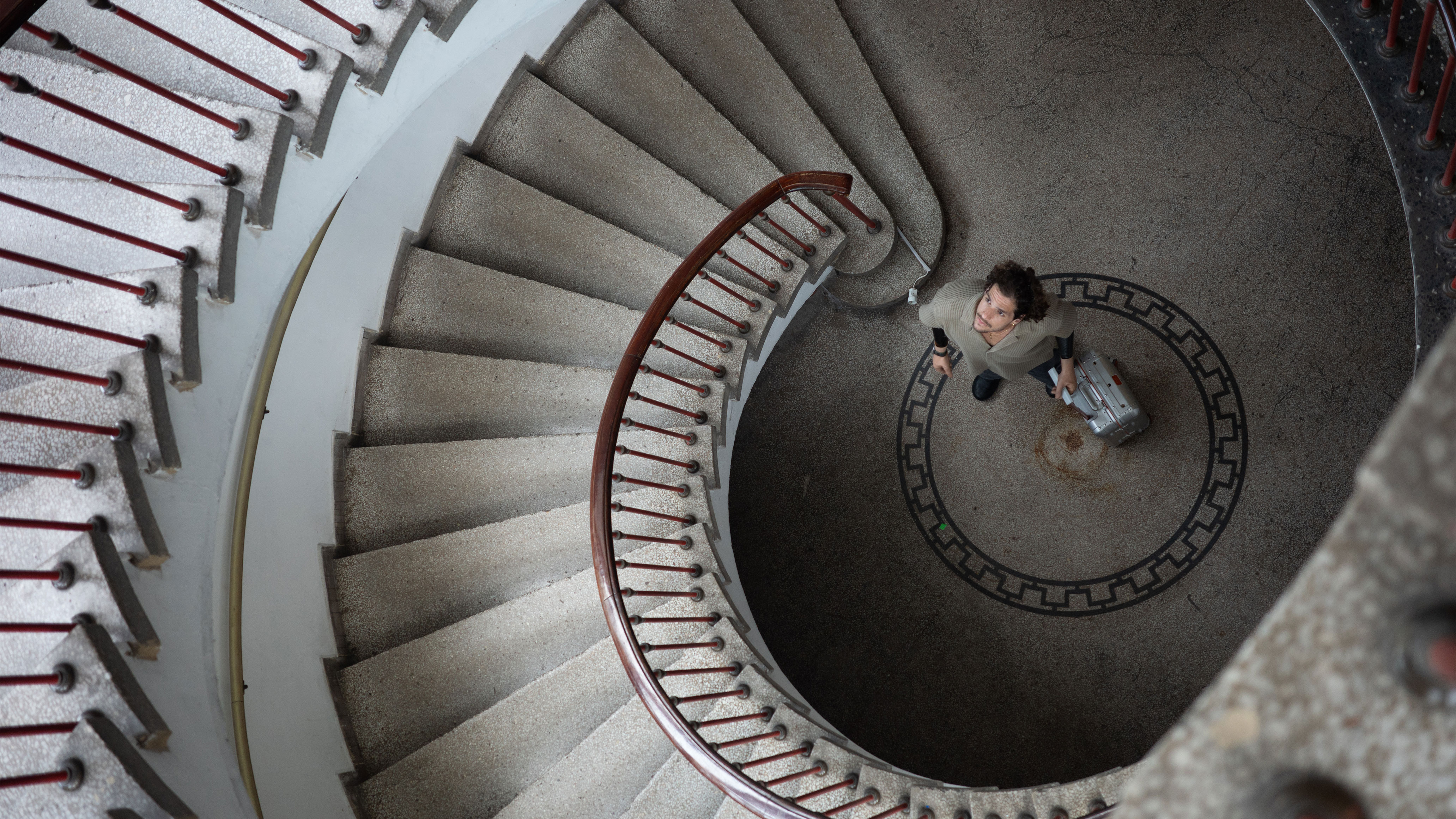Person with limited mobility standing at the bottom of a spiral staircase, symbolizing inaccessible architecture and the barriers highlighted in Ottobock’s Invisible Class campaign.