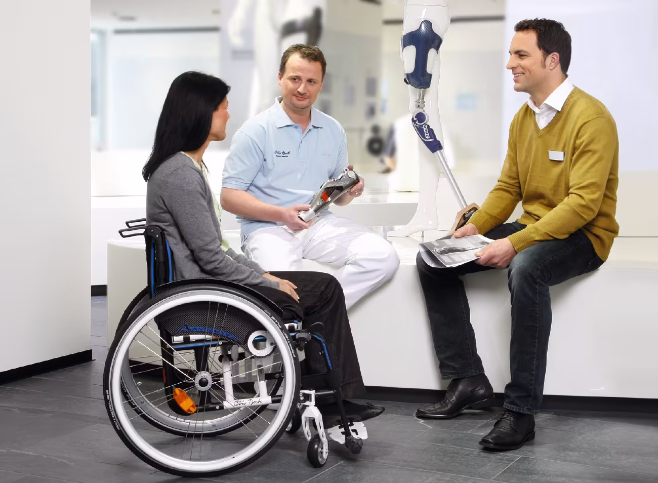 An amputee with a prosthetic leg faces a group of prosthetic users 