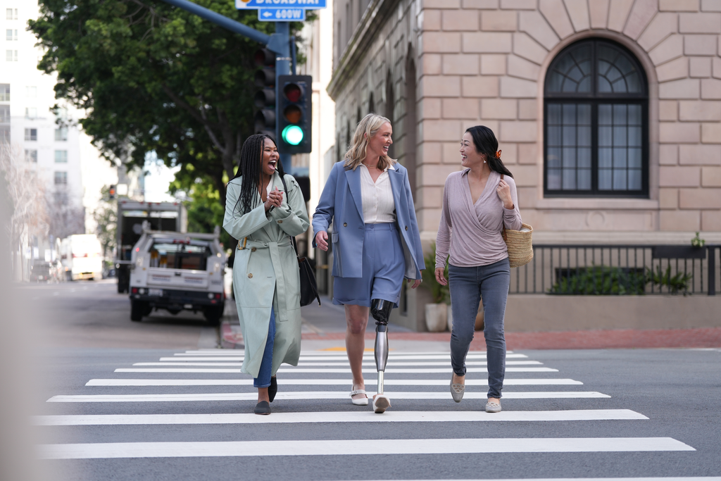 Genium X4 user Laura crosses the road during a fast‑paced stroll through the city with friends.