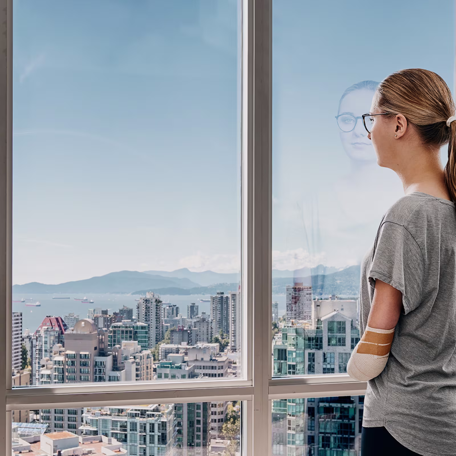 Eine Anwenderin steht am Fenster und guckt raus