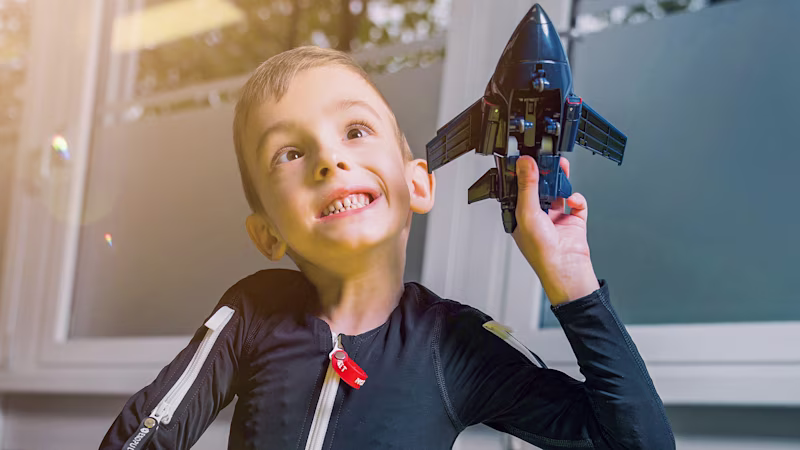 Cerebral palsy patient playing with his airplane in the Exopulse Mollii Suit