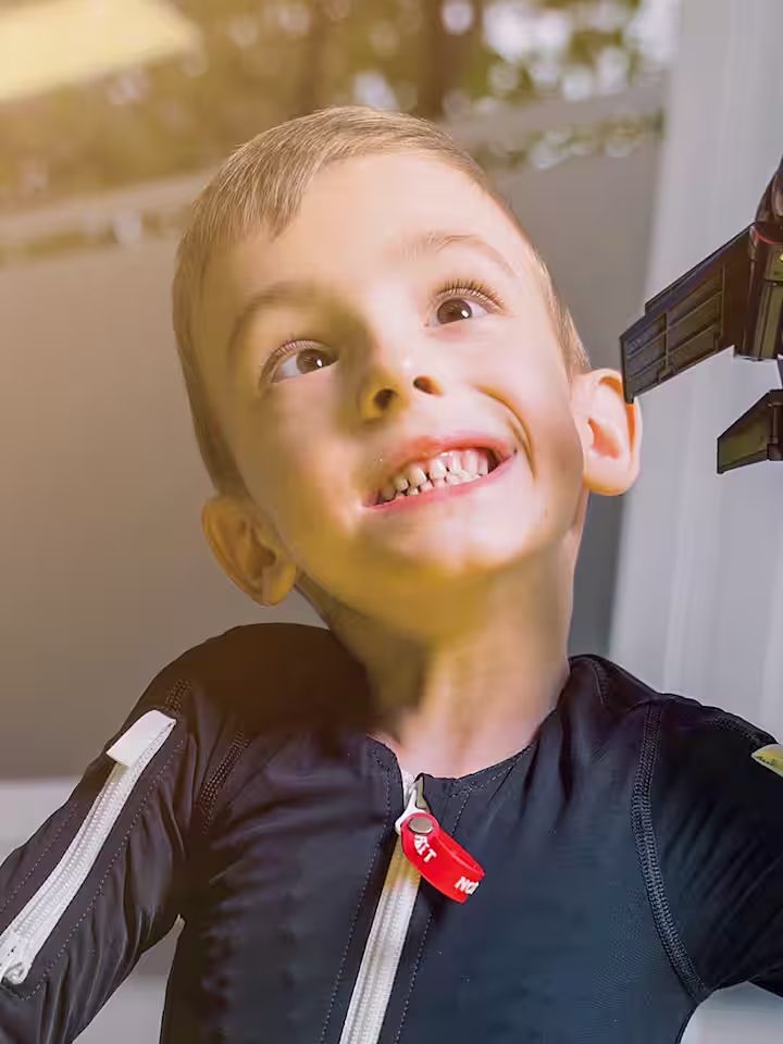 Exopulse Mollii Suit user Alexander playing with a toy aeroplane