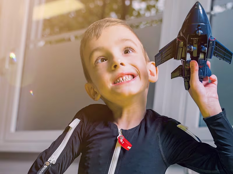Exopulse Mollii Suit user Alexander playing with a toy aeroplane