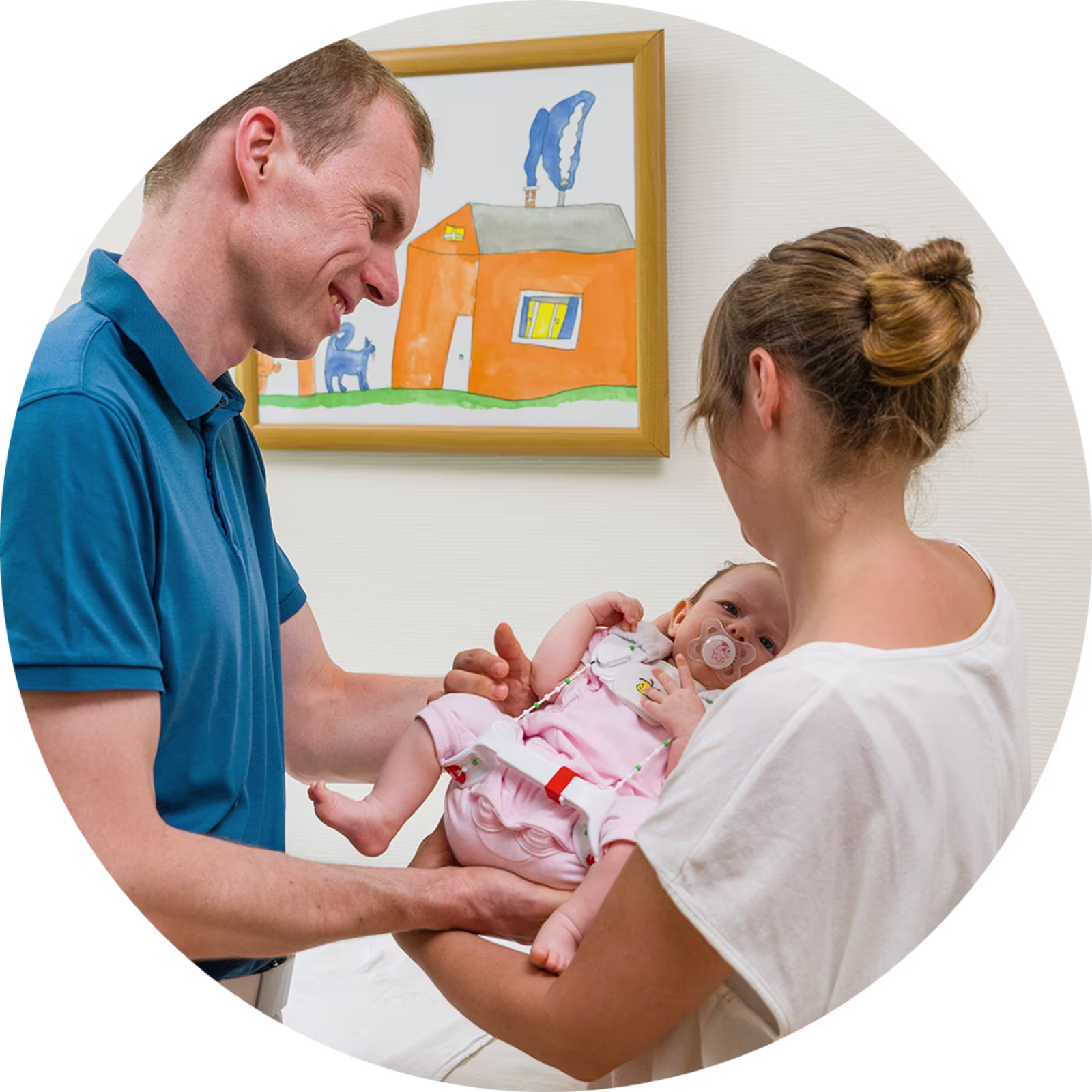 Eine Mutter hält ihr Kind auf dem Arm. Das Kind trägt aufgrund einer Hüftdysplasie eine Tübinger Hüftbeugeschiene von Ottobock.