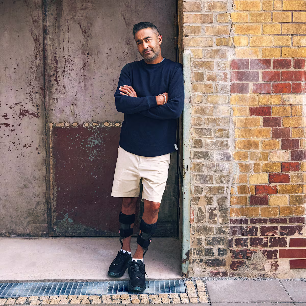 Ein männlicher Anwender lehnt sich an einer Wand an, dabei trägt er die WalkOn Reaction lateral Unterschenkelorthese von Ottobock.