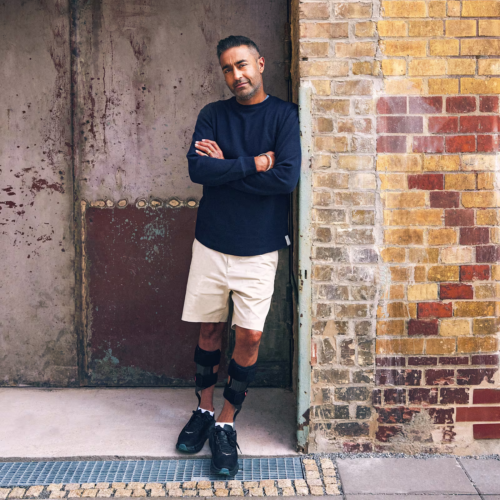 Ein männlicher Anwender lehnt sich an einer Wand an, dabei trägt er die WalkOn Reaction lateral Unterschenkelorthese von Ottobock.