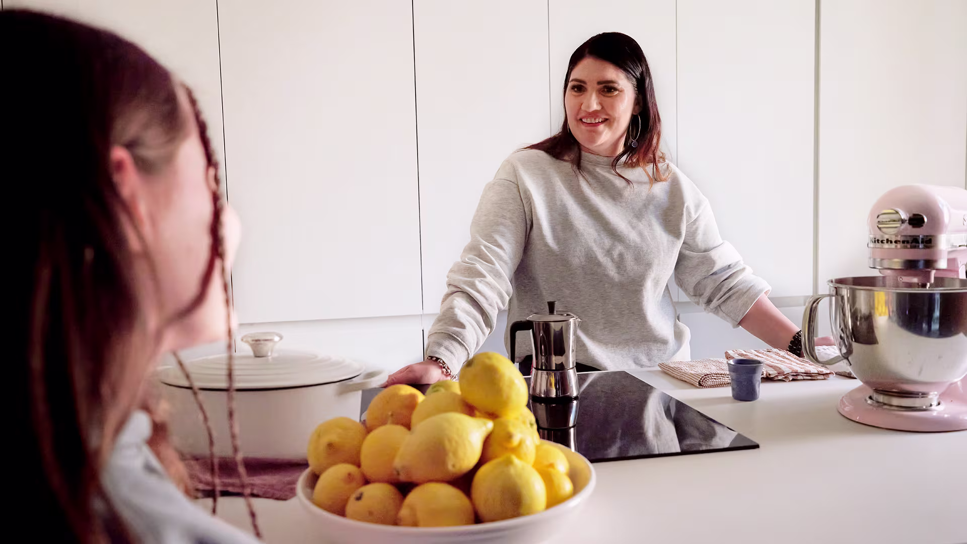 Ottobock Exopulse Mollii Suit user Elisa smiling at young girl in kitchen