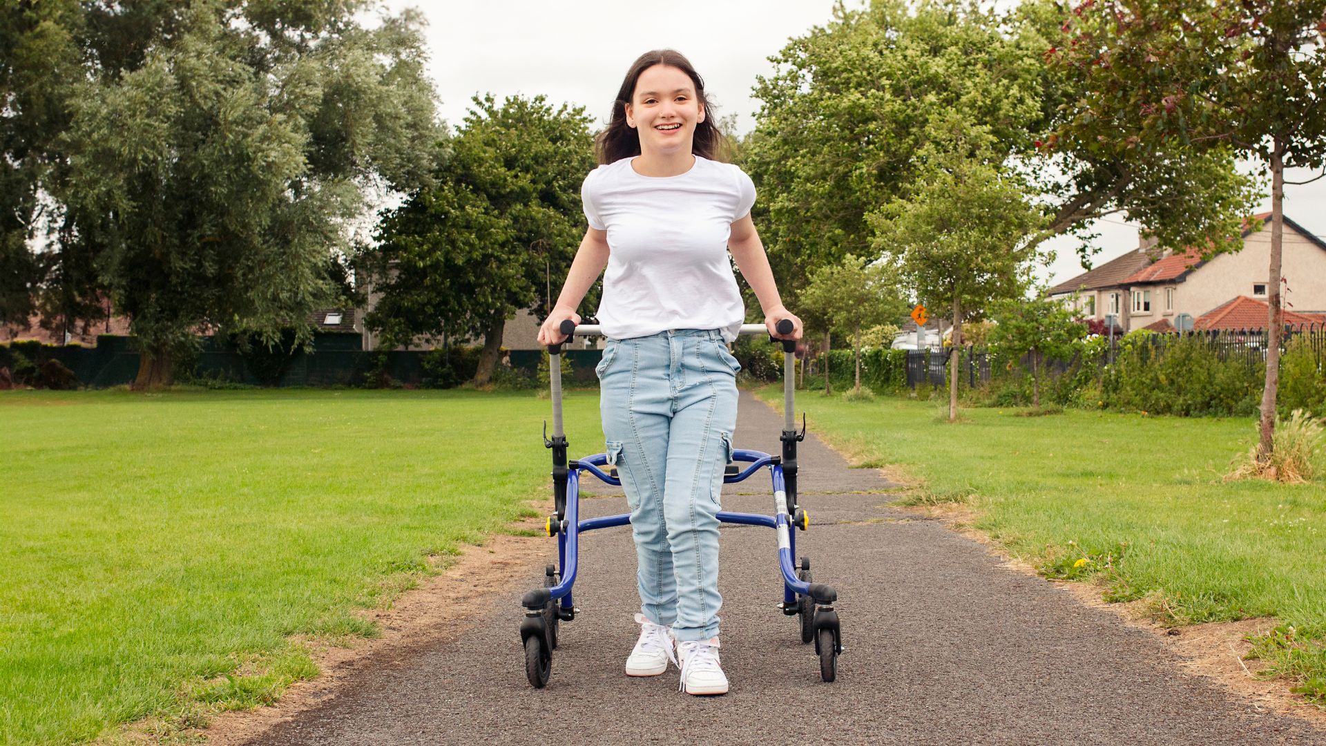 Cerebral Palsy patient walks with a walker in the park