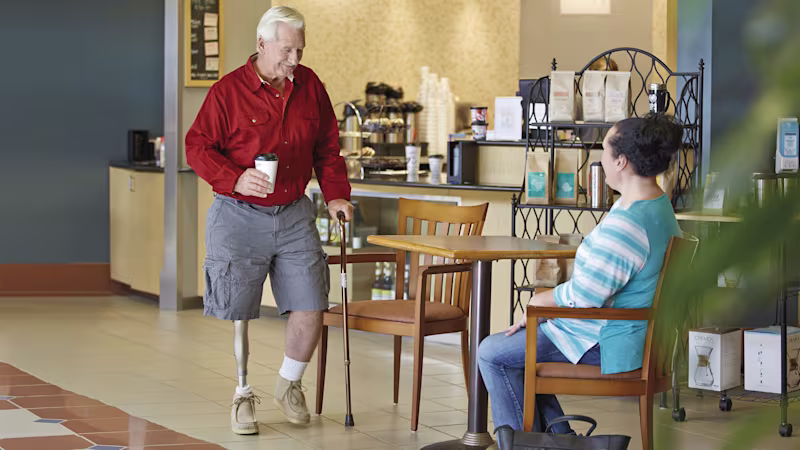 Bob, Kenevo Mikroişlemci Diziyle bir kafe masasına bir fincan kahve taşıyor.