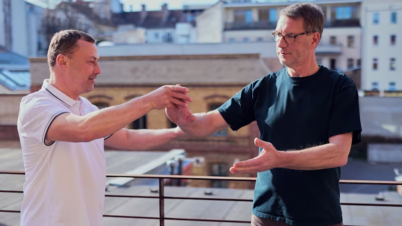 Tai chi instructor Mirko Lorenz assists an amputee with training