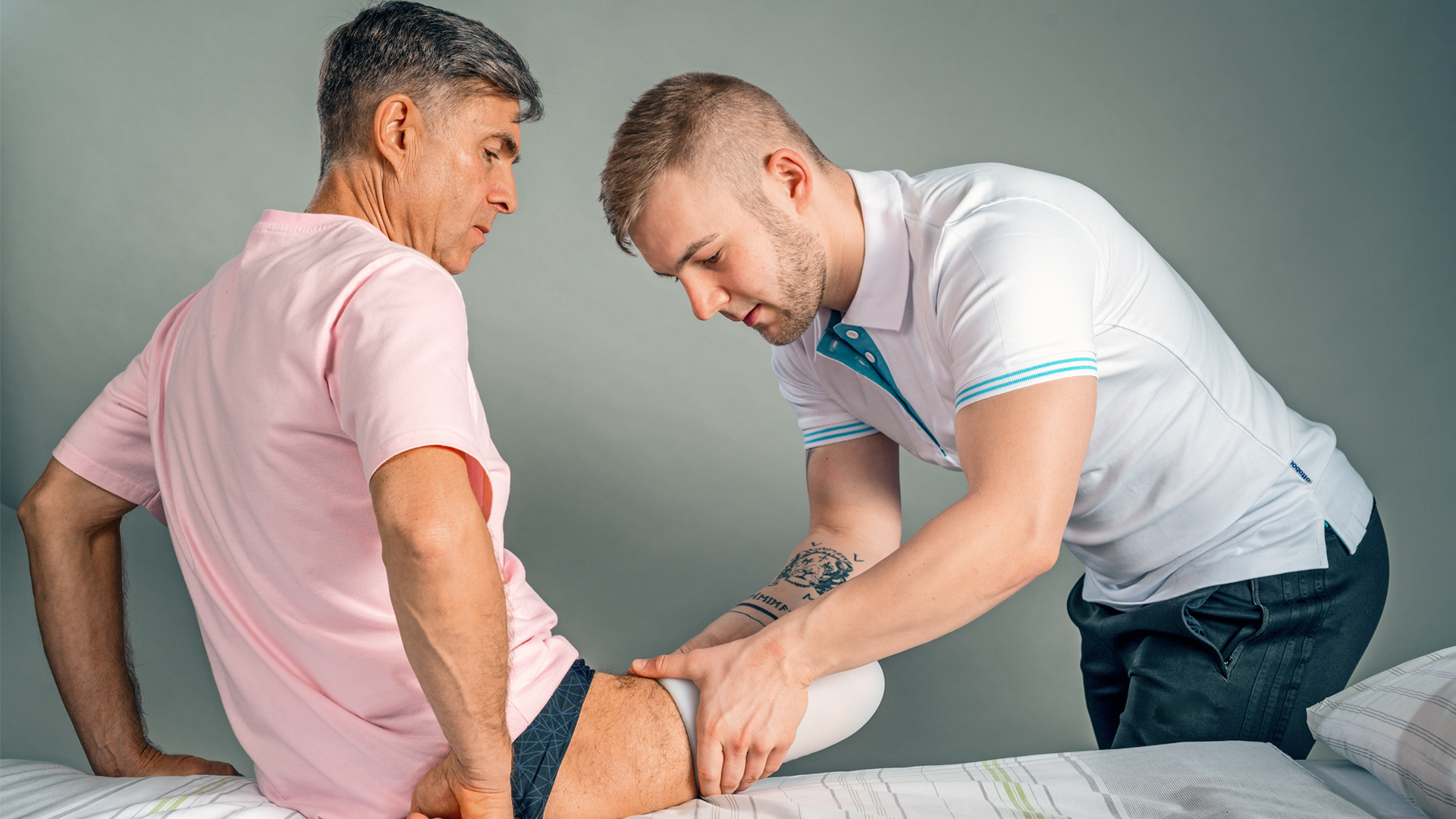 Специалист по реабилитации показывает пациенту как правильно надевать компрессионный лайнер.