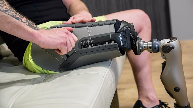 Ottobock Kenevo microprocessor knee user sitting on a couch and adjusting his Varos socket