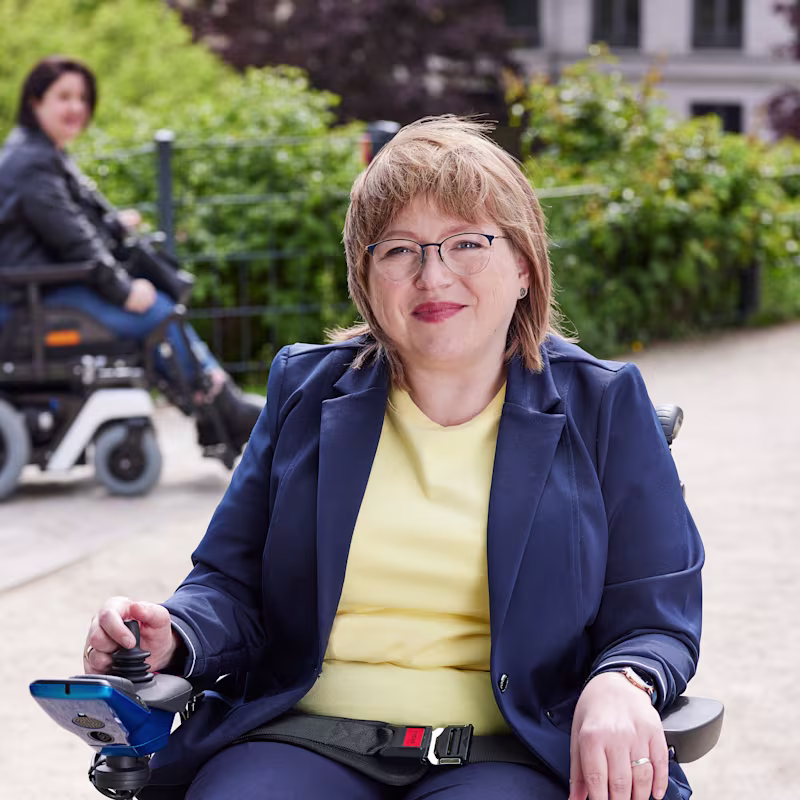 Juvo B5'te oturan Anja'nın Berlin'de bir parkta güneşin tadını çıkarırken çekilmiş portre fotoğrafı.