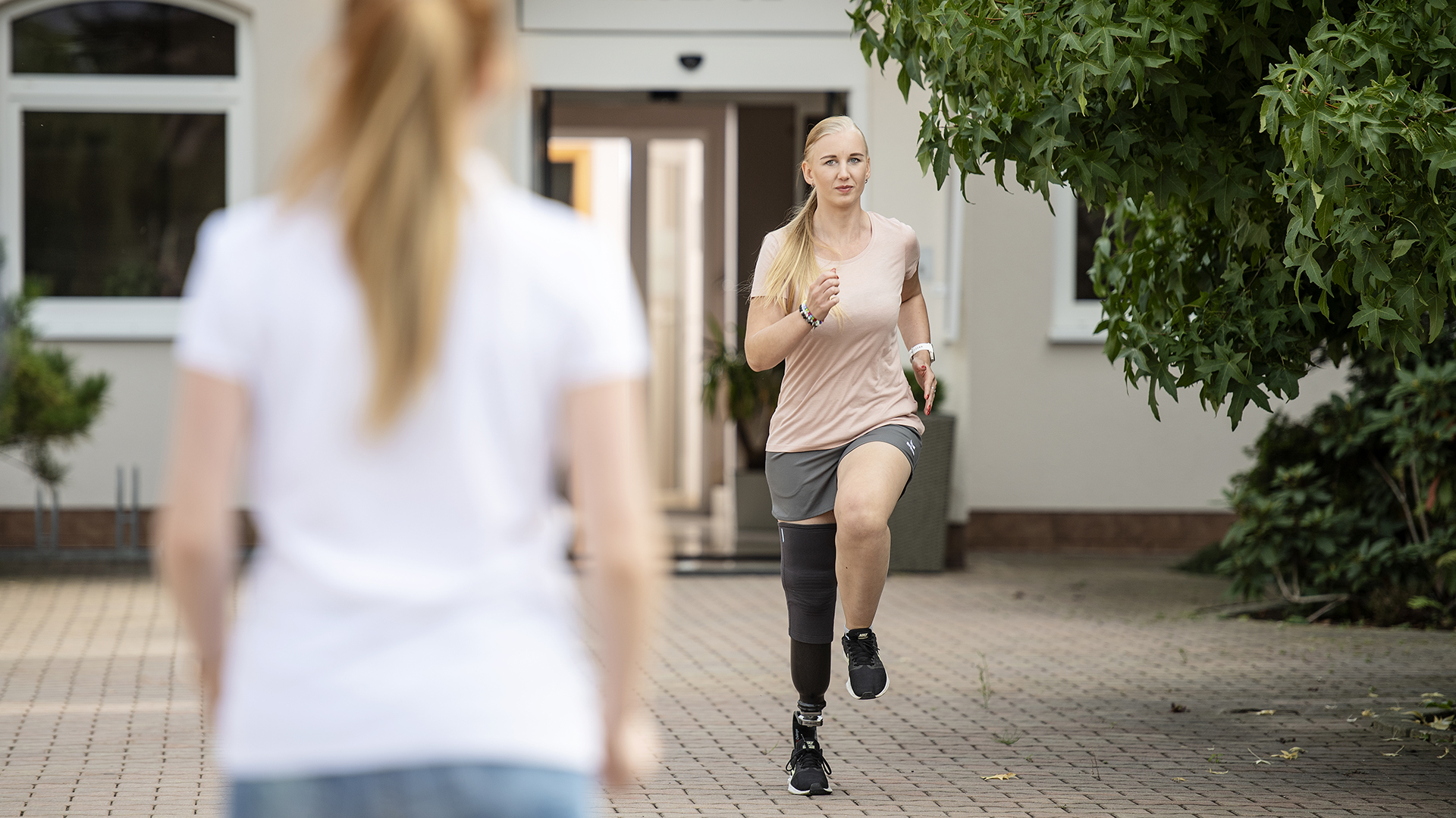 Eine junge, beinamputierte Frau macht Knieheben mit ihrer Sportprothese von Ottobock.