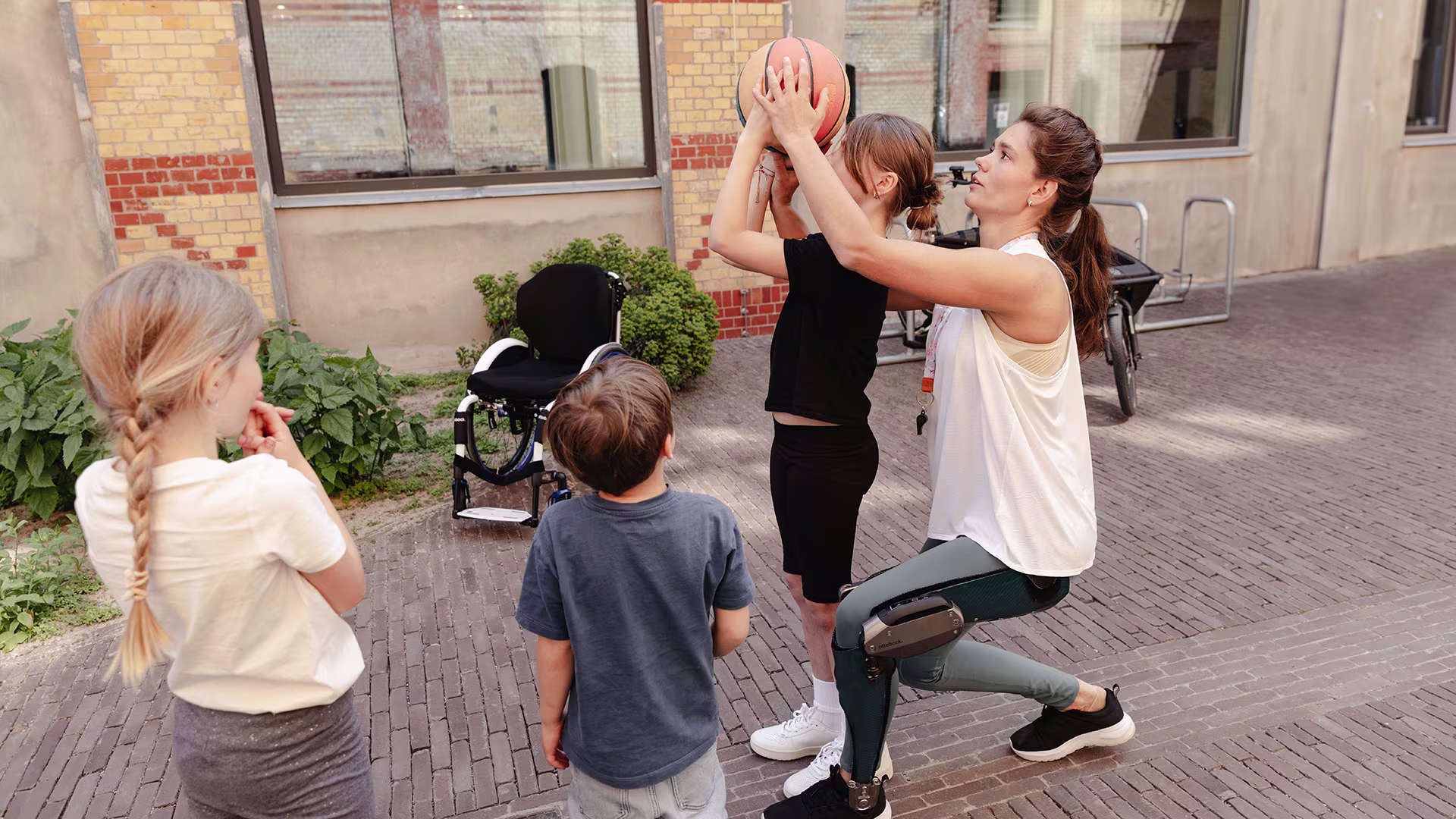 An Ottobock C-Brace user playing basketball with a group of kids