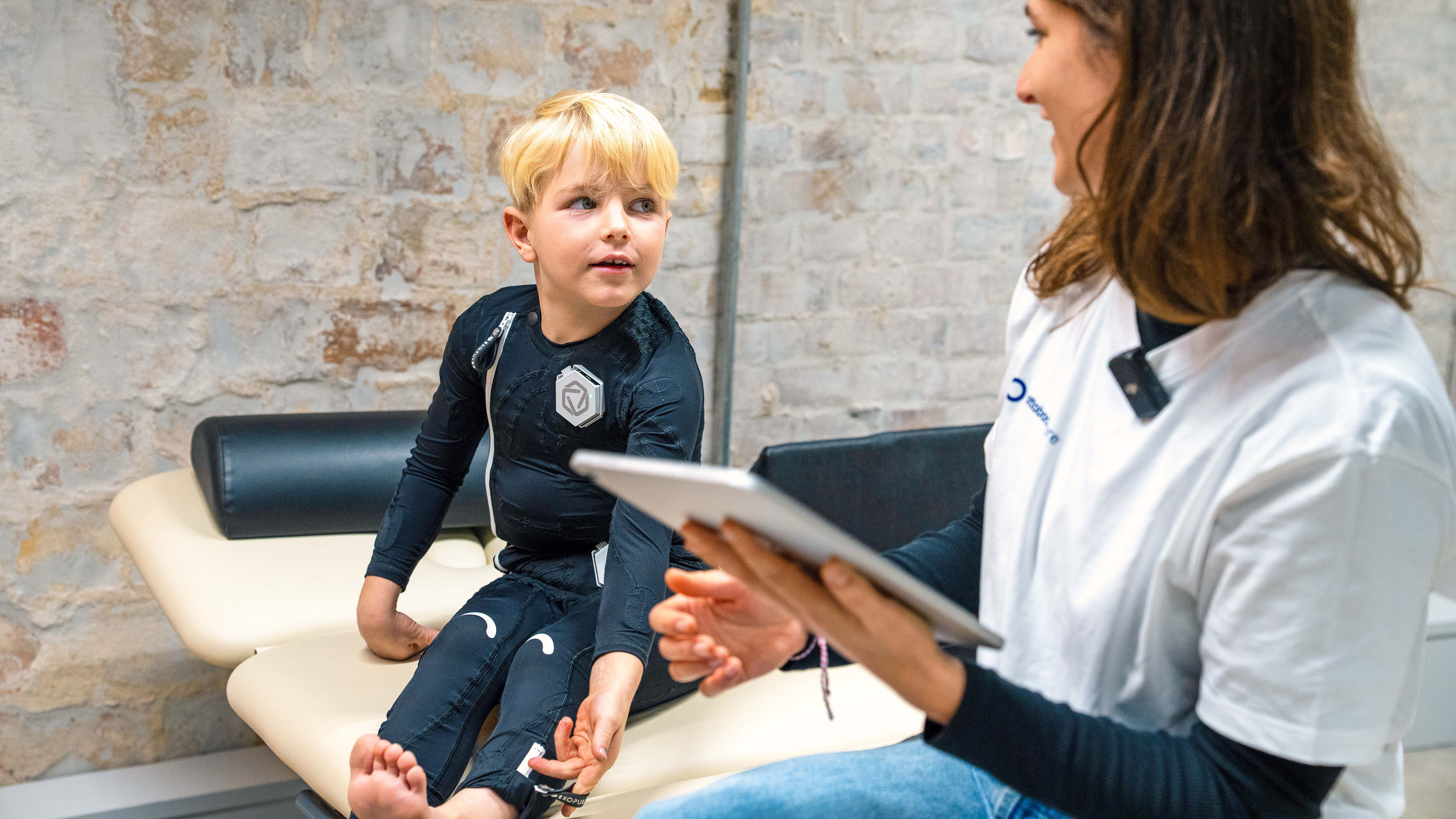 A cerebral Palsy patient is sitting on a chair next to a physician