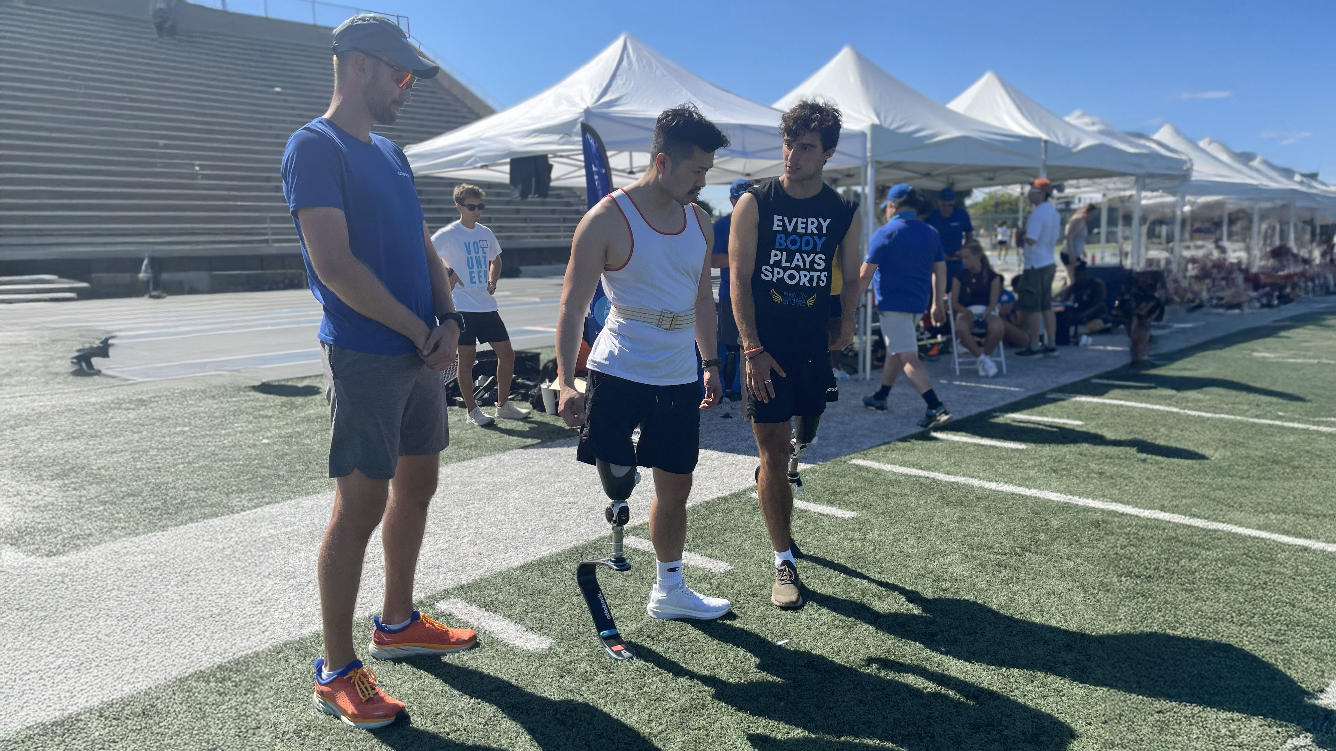 Ottobock Ambassador and Paralympian Ezra Frech and Ottobock employee helping a Running Clinic attendee adjust to a running blade