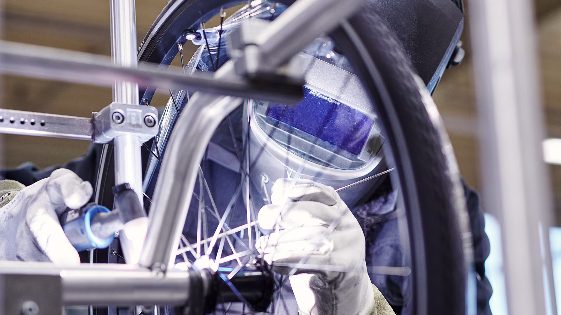 Close-up of a technician with a welding mask welding an ottobock invader wheelchair
