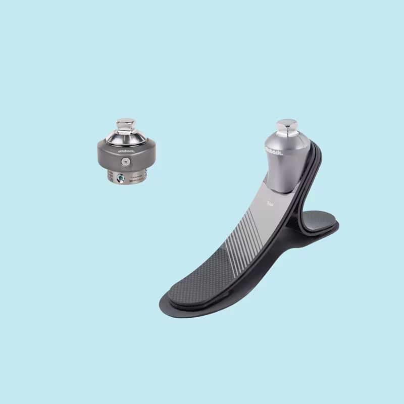 Vor blauem Hintergrund sind der Trias Prothesenfuß und der Quickchange Adapter von Ottobock zu sehen.