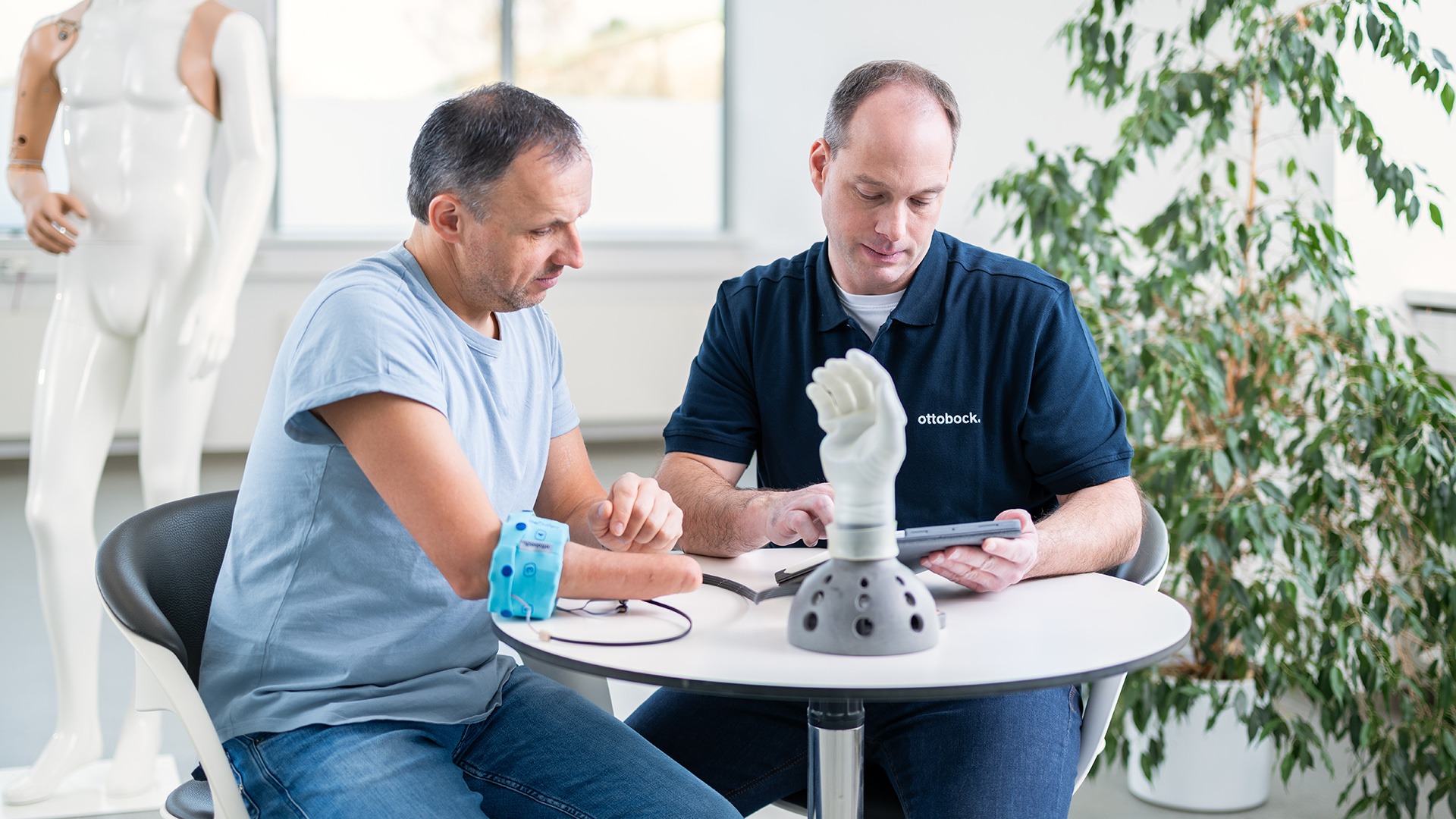An orthopaedic technician and a prosthetic user evaluate the prosthesis using the myosmart cuff and the connectgrip app.