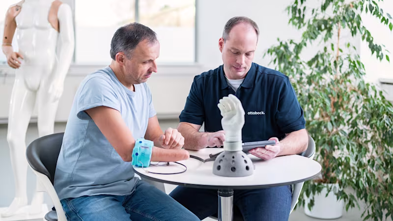An orthopaedic technician and a prosthetic user evaluate the prosthesis using the myosmart cuff and the connectgrip app.