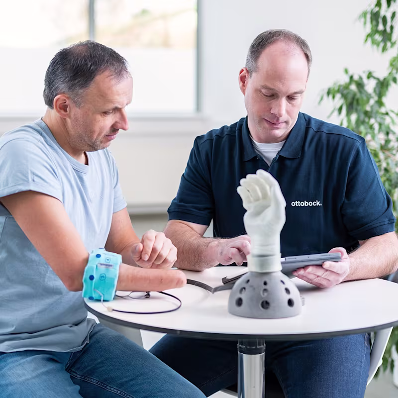 An orthopaedic technician and a prosthetic user evaluate the prosthesis using the myosmart cuff and the connectgrip app.