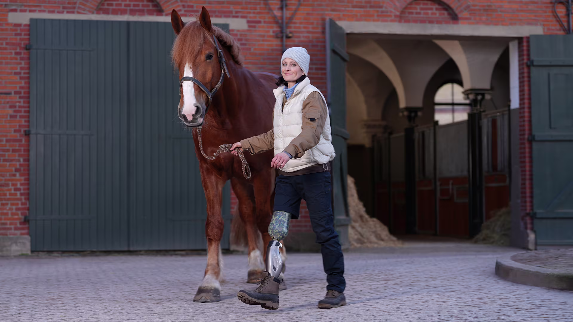 A woman using a Genium X4 microprocessor prosthetic knee leading her horse.