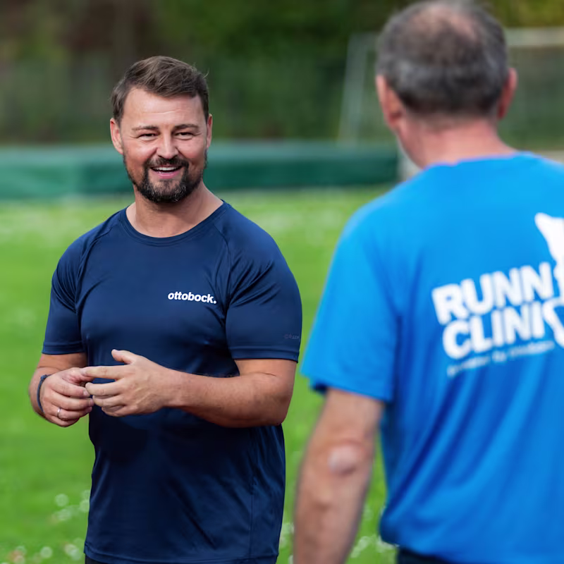 Coach Heinrich Popow unterhält sich mit einem Teilnehmer bei der Ottobock Running Clinic 2024.
