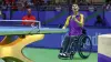 A table tennis player in a wheelchair celebrates their victory 