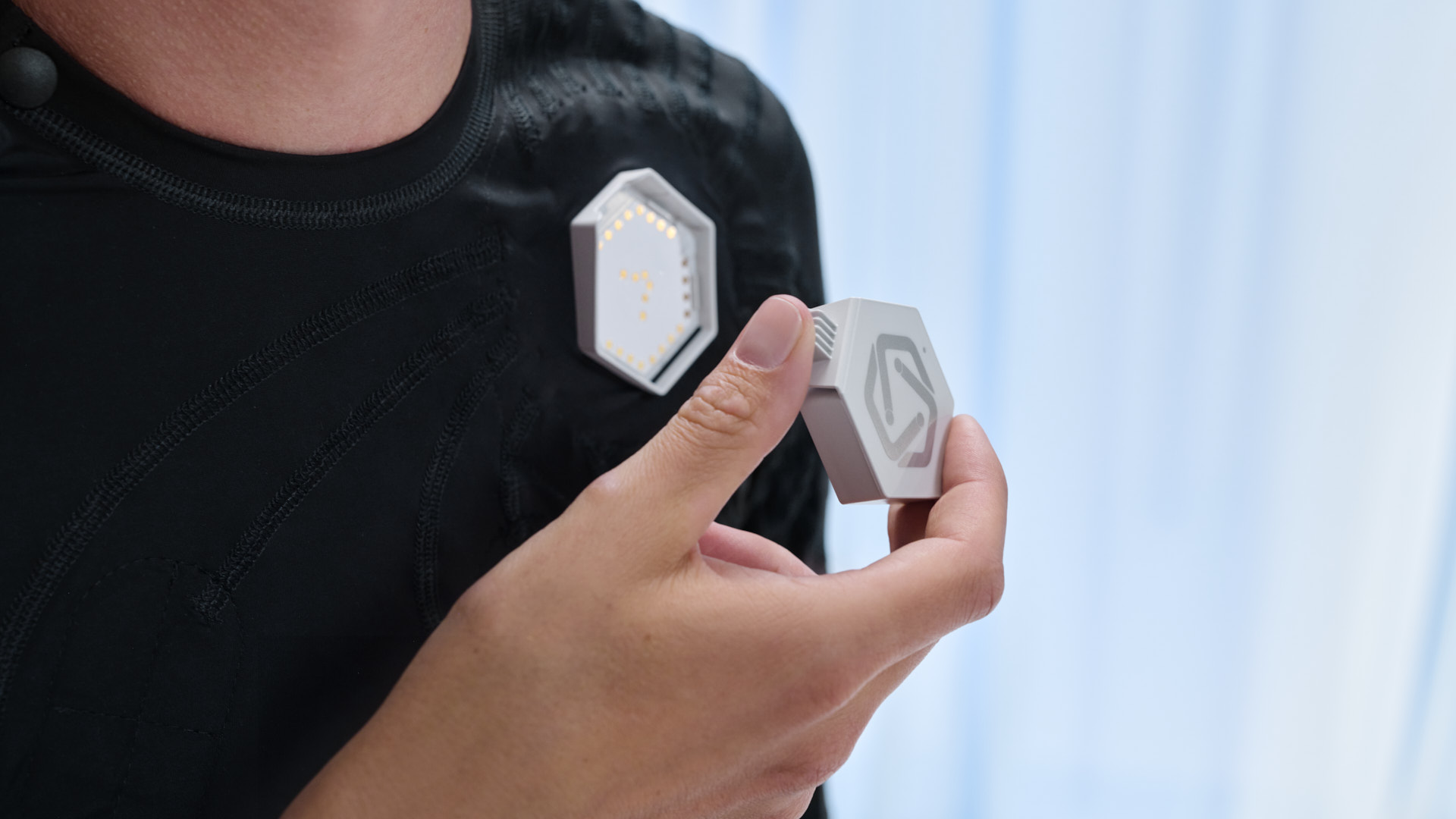 Ottobock user Ricky connects the exopulse control unit to the suit.