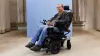 Power wheelchair user Tobias is in Ottobock Juvo B7, in front of a blue photo studio background.