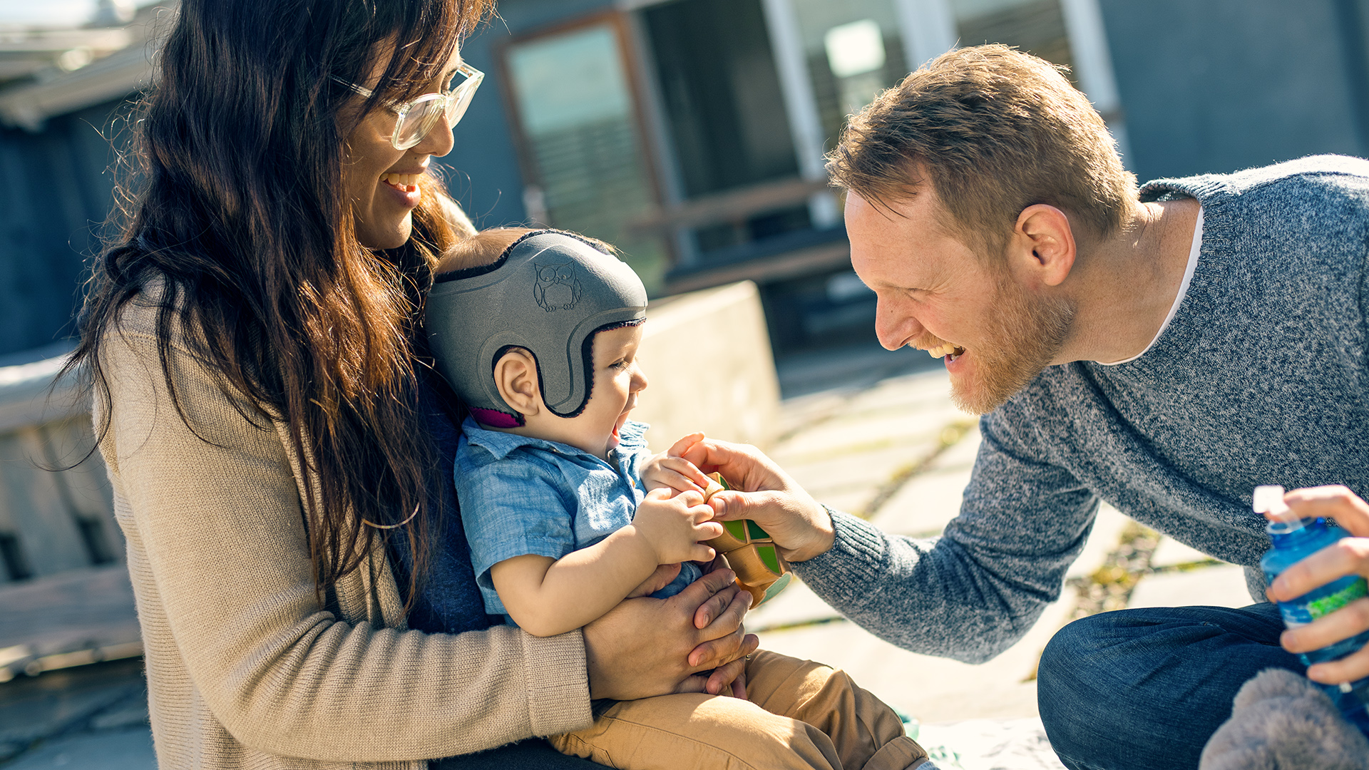 Harrison is wearing the MyCRO Band helmet and laughing with his parents.
