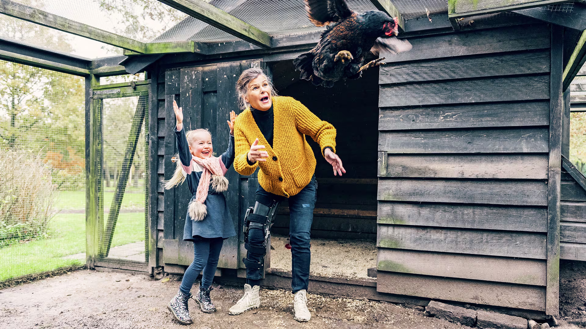Marjan is wearing the C-Brace and playing in the garden with a child.