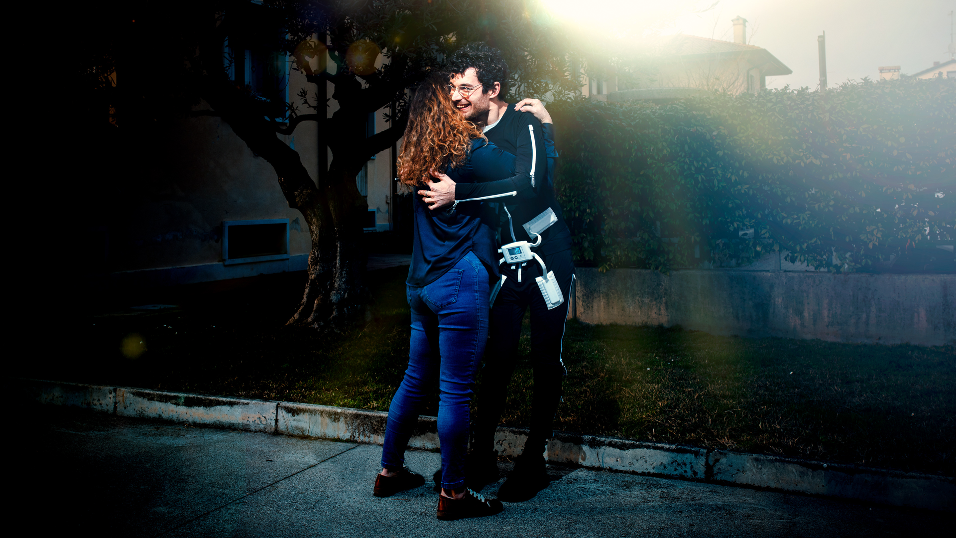 Ottobock exopulse user in front of a blue background picking up Domino pieces
