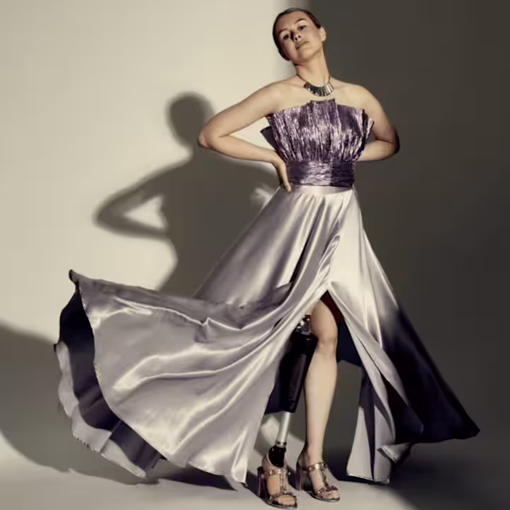 Sarah wearing her C-Leg prosthesis posing in a flowing dress on a modelling photoshoot.