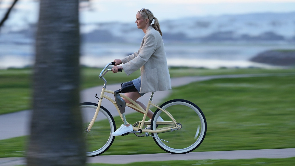 Dziewczyna po amputacji jedzie na rowerze w protezie Genium X4, która posiada specjalny tryb rowerowy