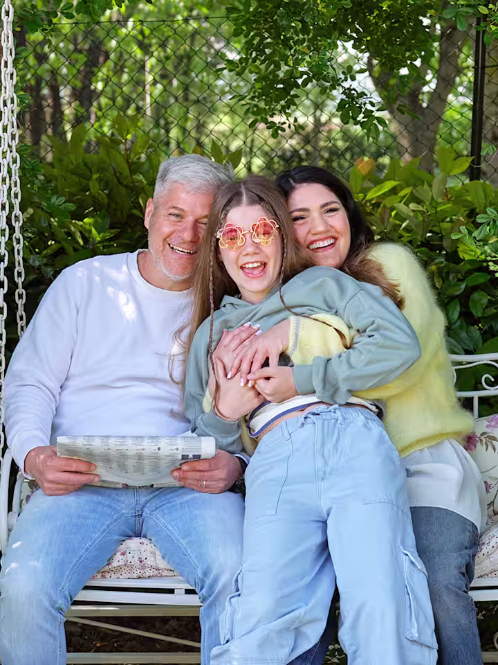 Ottobock Exopulse Mollii Suit user Elisa with family on garden swing