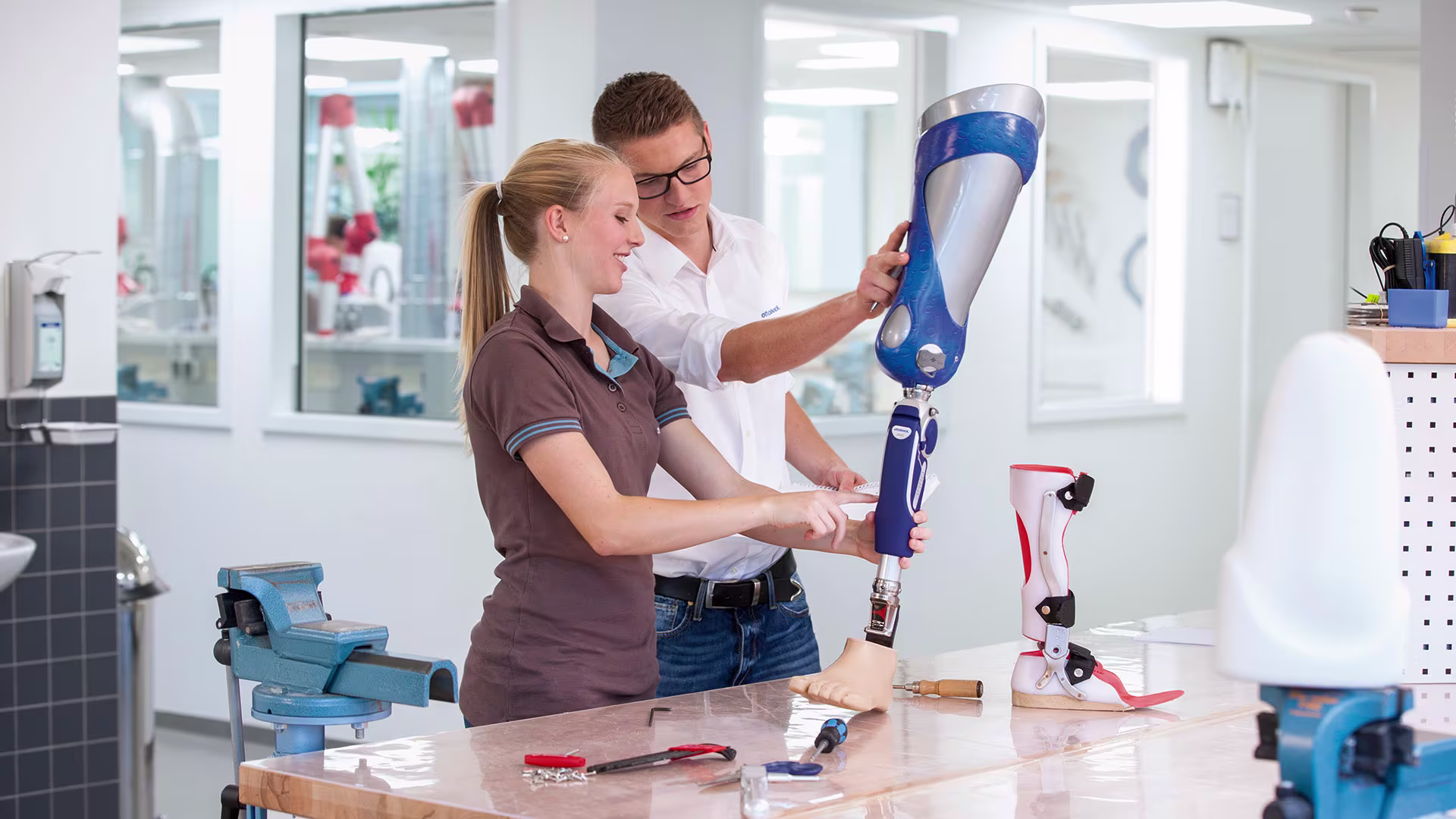 Coworkers inspecting a prosthetic leg in an O&P facility